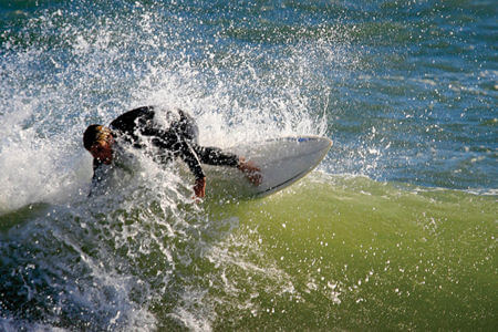 Man surfing near the beach in Buxton, NC.