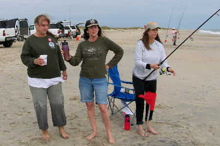 Three ladies on Buxton beach fishing in the Cape Hatteras Anglers Club Tournament.
